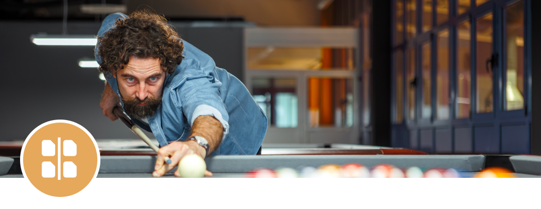 Man playing billiards, aiming shot