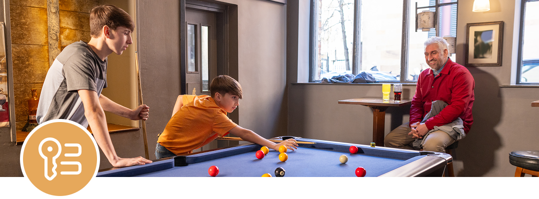 Teens playing pool in a cozy room