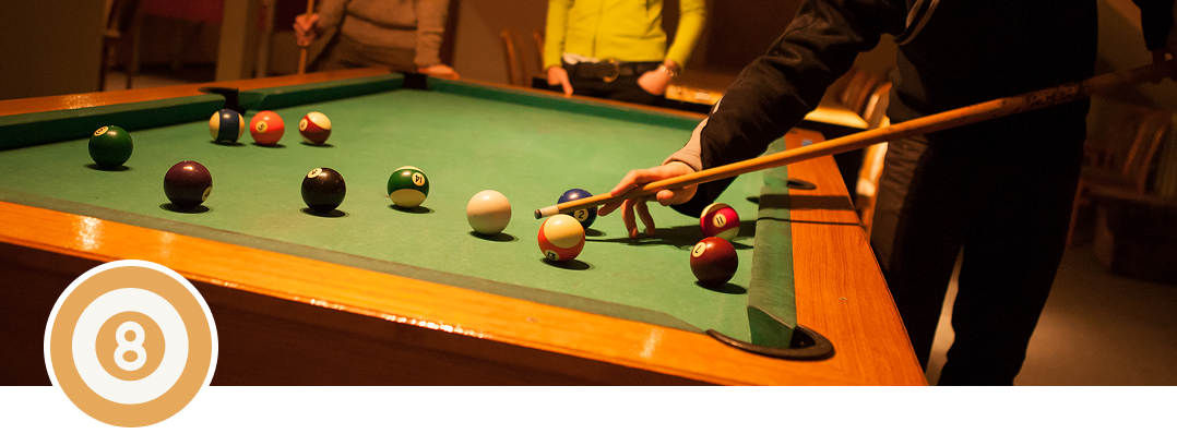 Billiards game in progress, players focused