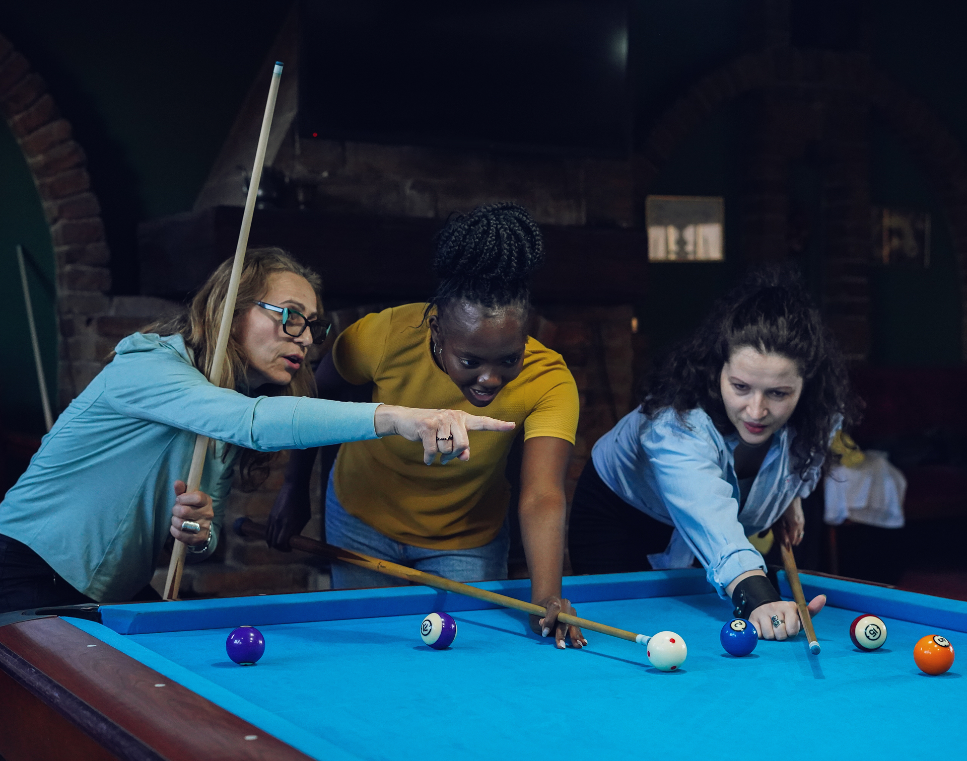 Women strategizing during pool game