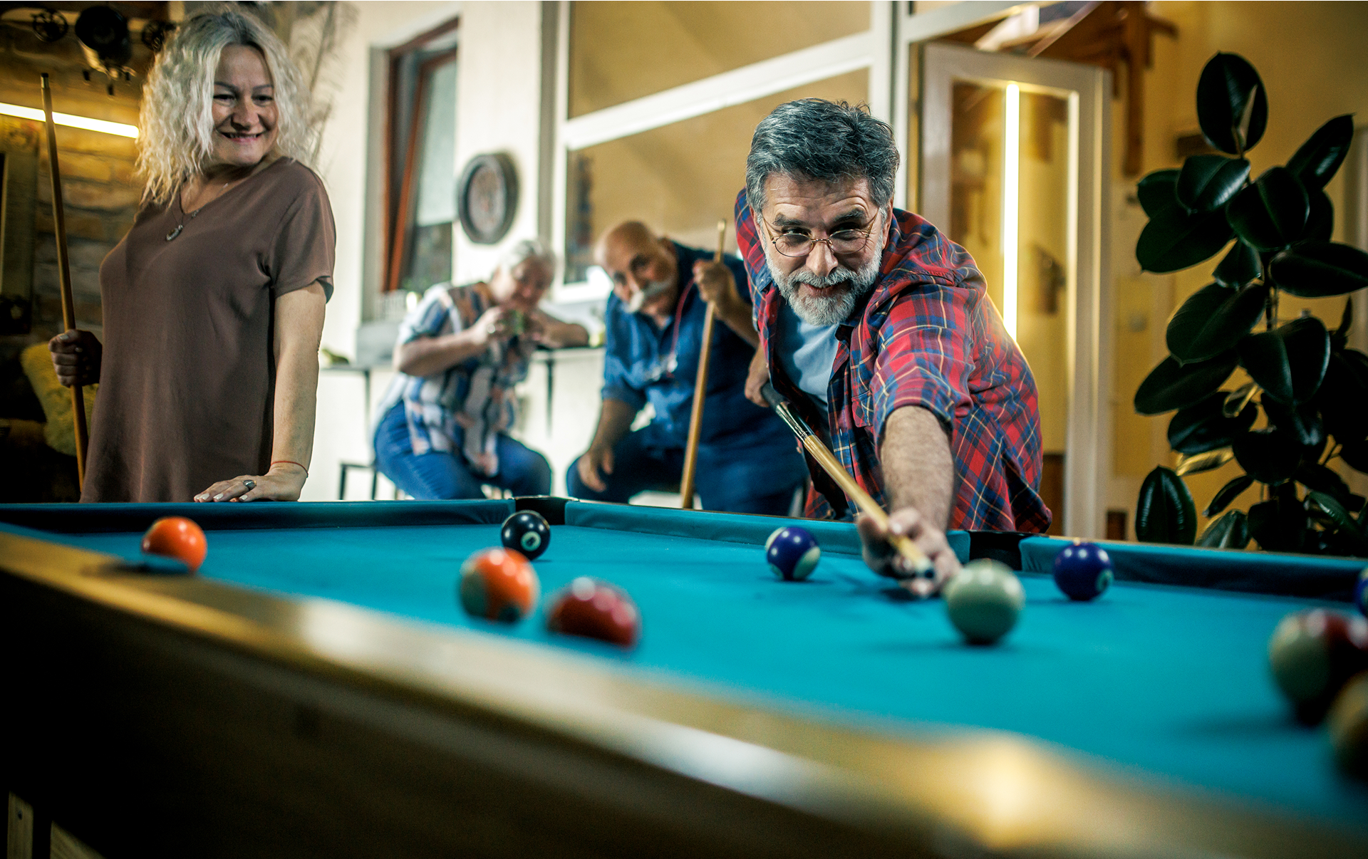 Man playing pool with friends watching