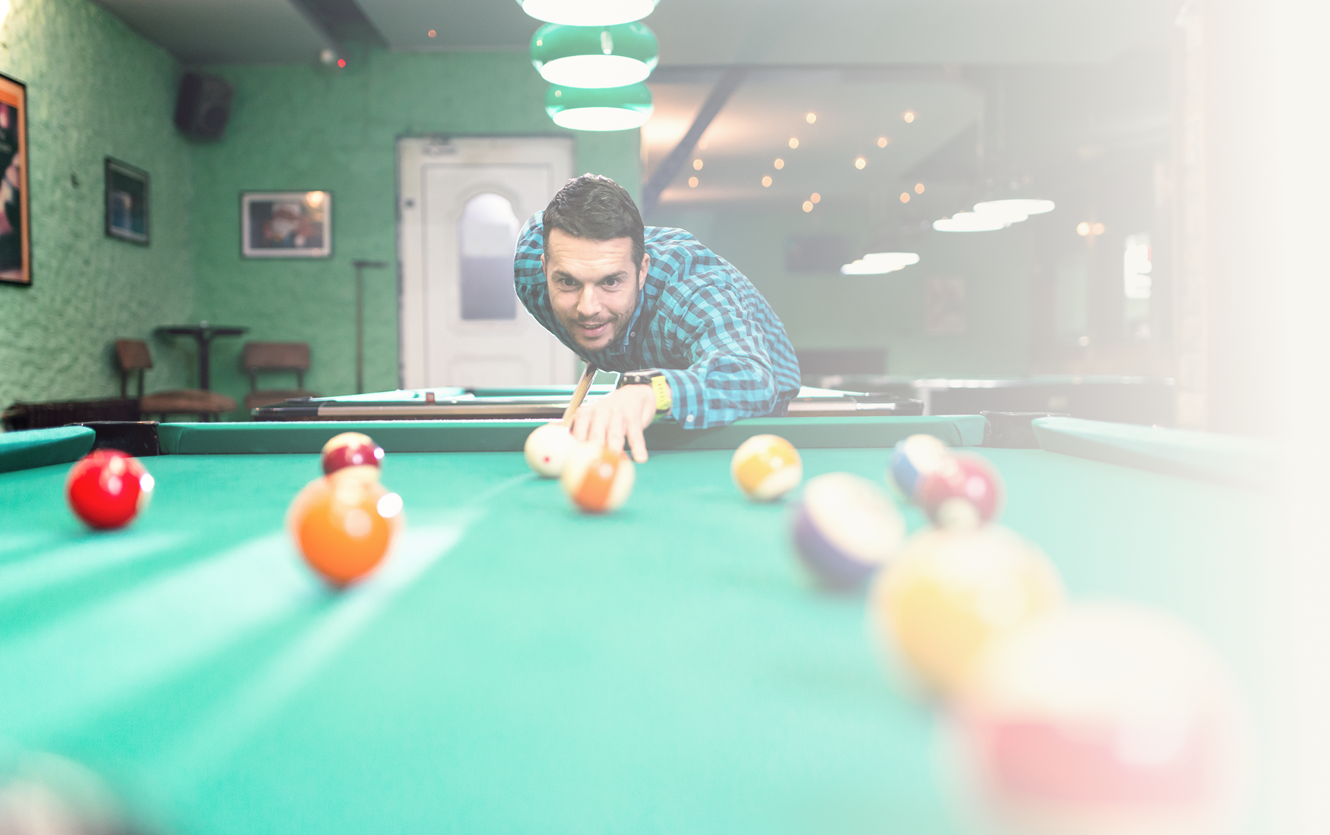 Man playing pool in a dim room