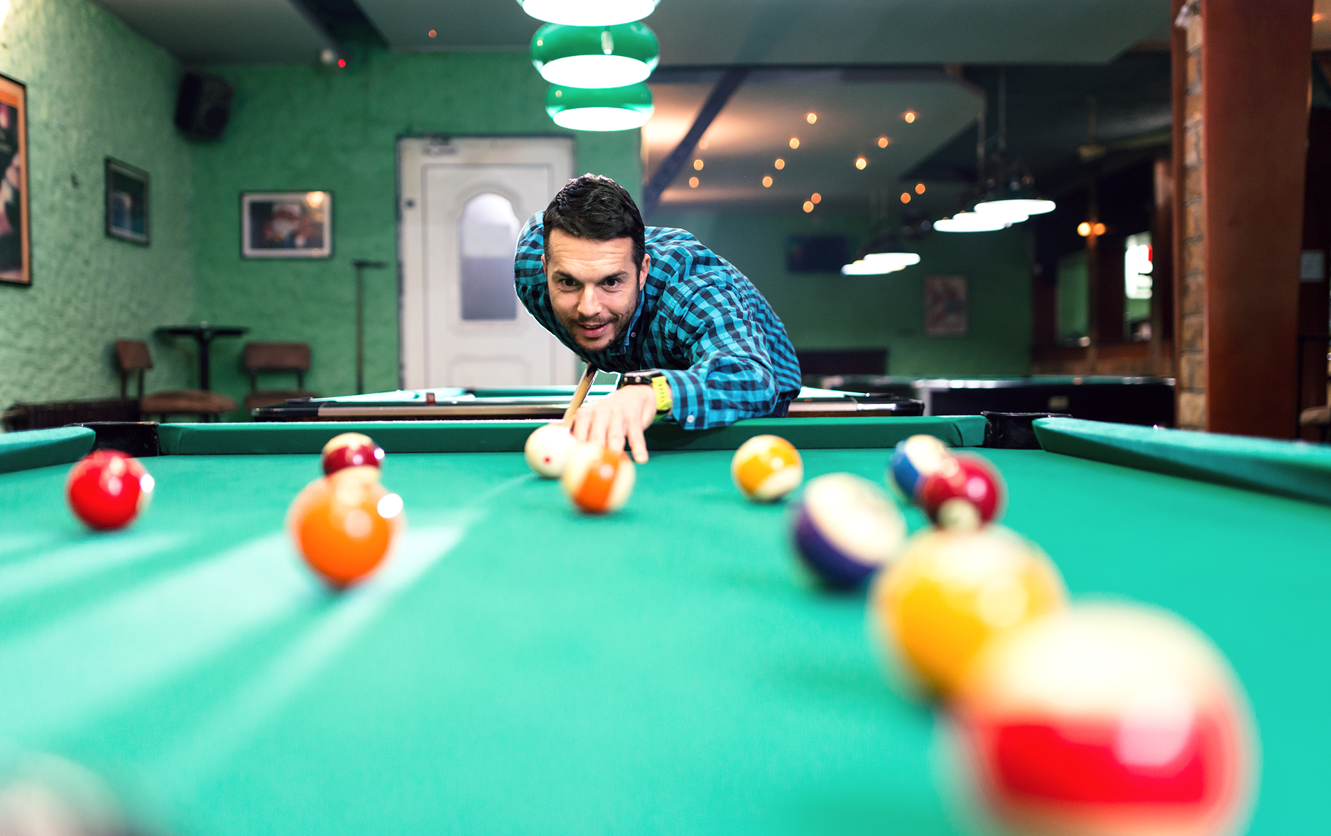Focused man playing billiards in bar