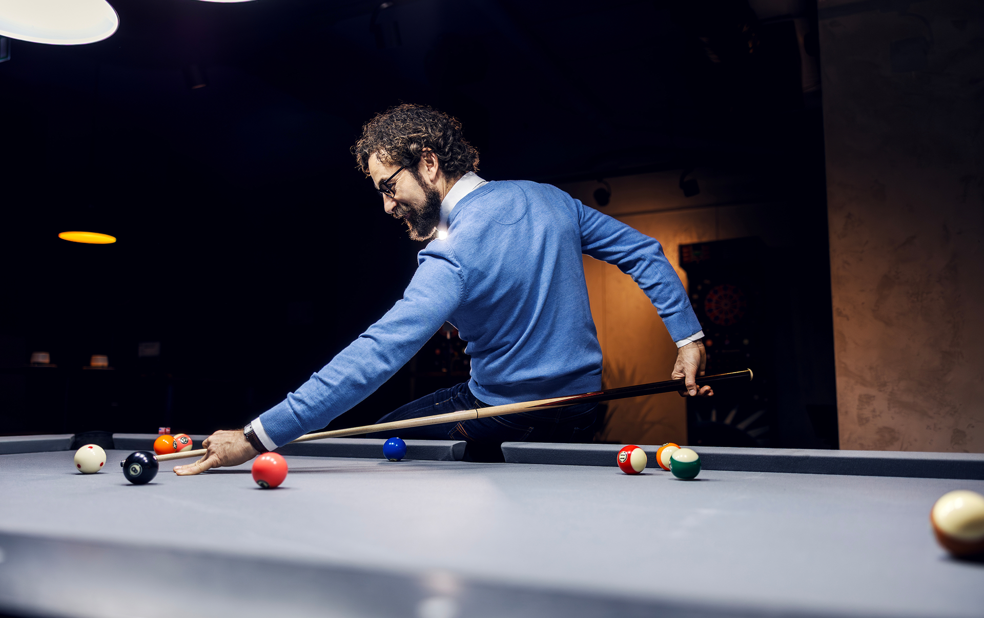 Man playing pool in dimly lit room